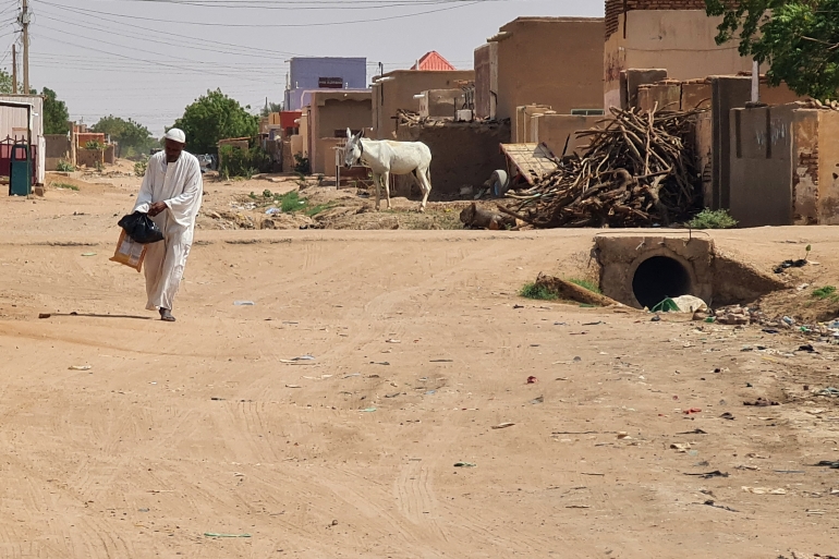 رجل في الخرطوم يحمل أكياسًا بيديه