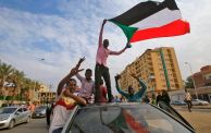 محتجون يحملون علم السودان