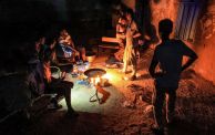 TOPSHOT - People sit around food cooking on a bonfire at a school that has been transformed into a shelter for people displaced by conflict in Sudan's northern border town of Wadi Halfa near Egypt late on September 11, 2023. The war between Sudan's rival generals since April 15 has uprooted more than five million people, including one million who fled across borders, according to United Nations figures. Nearly 7,500 people have been killed, according to a conservative estimate from the Armed Conflict Locati