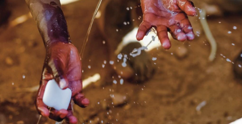 طفل يغسل يديه بالماء والصابون