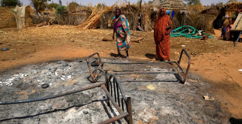 آثار أعمال في دارفور - امرأتان أمام أدوات محترقة